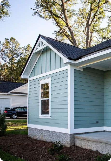image (10) Repaired fiber cement siding by Urban Shield Roofing on blue residential home with white trim.